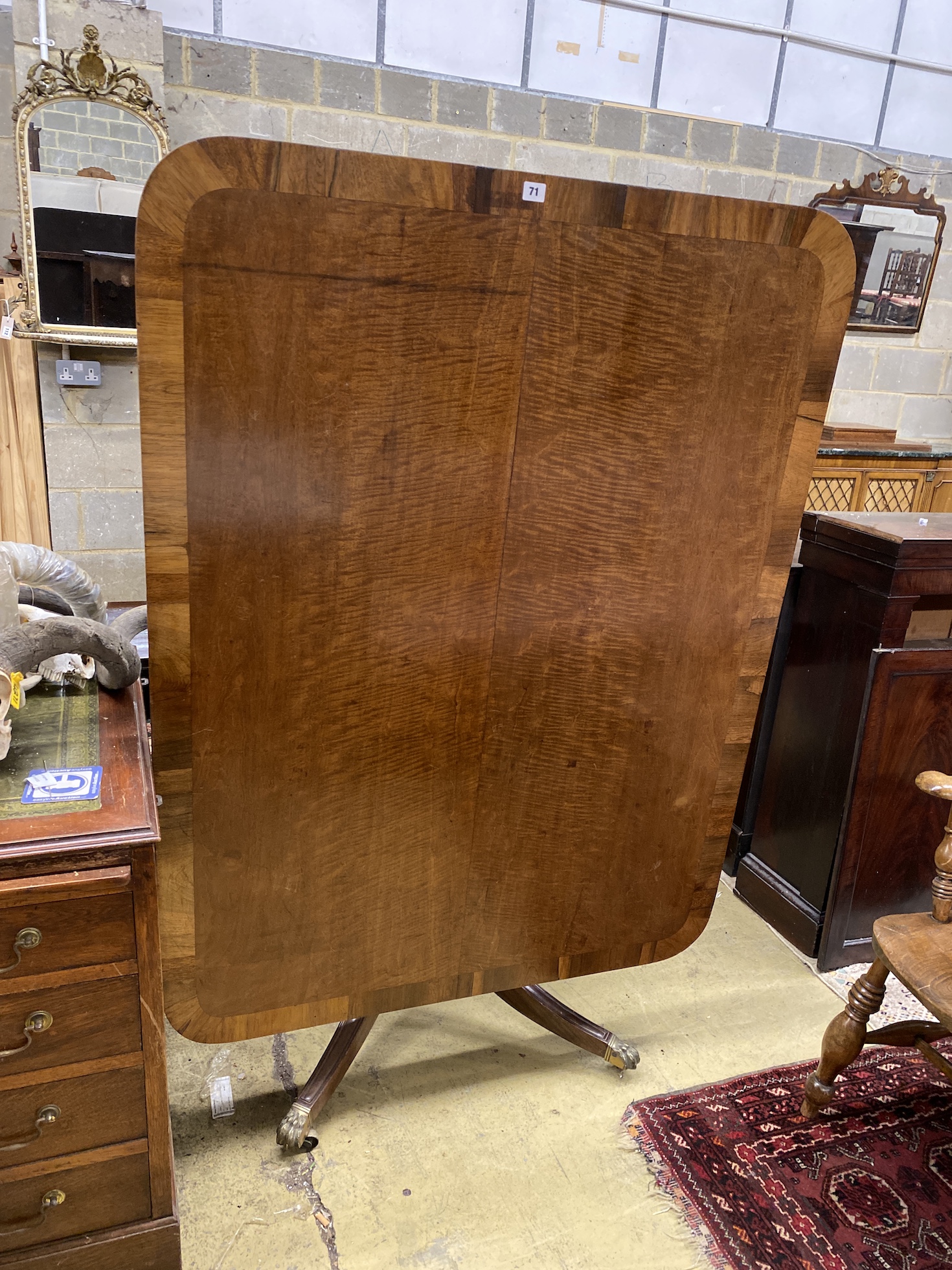 A Regency rosewood banded fiddle back mahogany rectangular tilt top dining table, width 138cm, depth 105cm, height 72cm